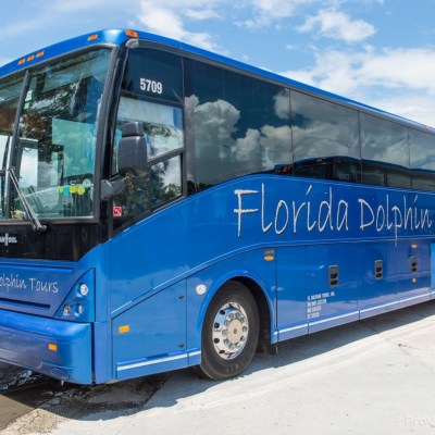 a blue bus parked on the side of a road